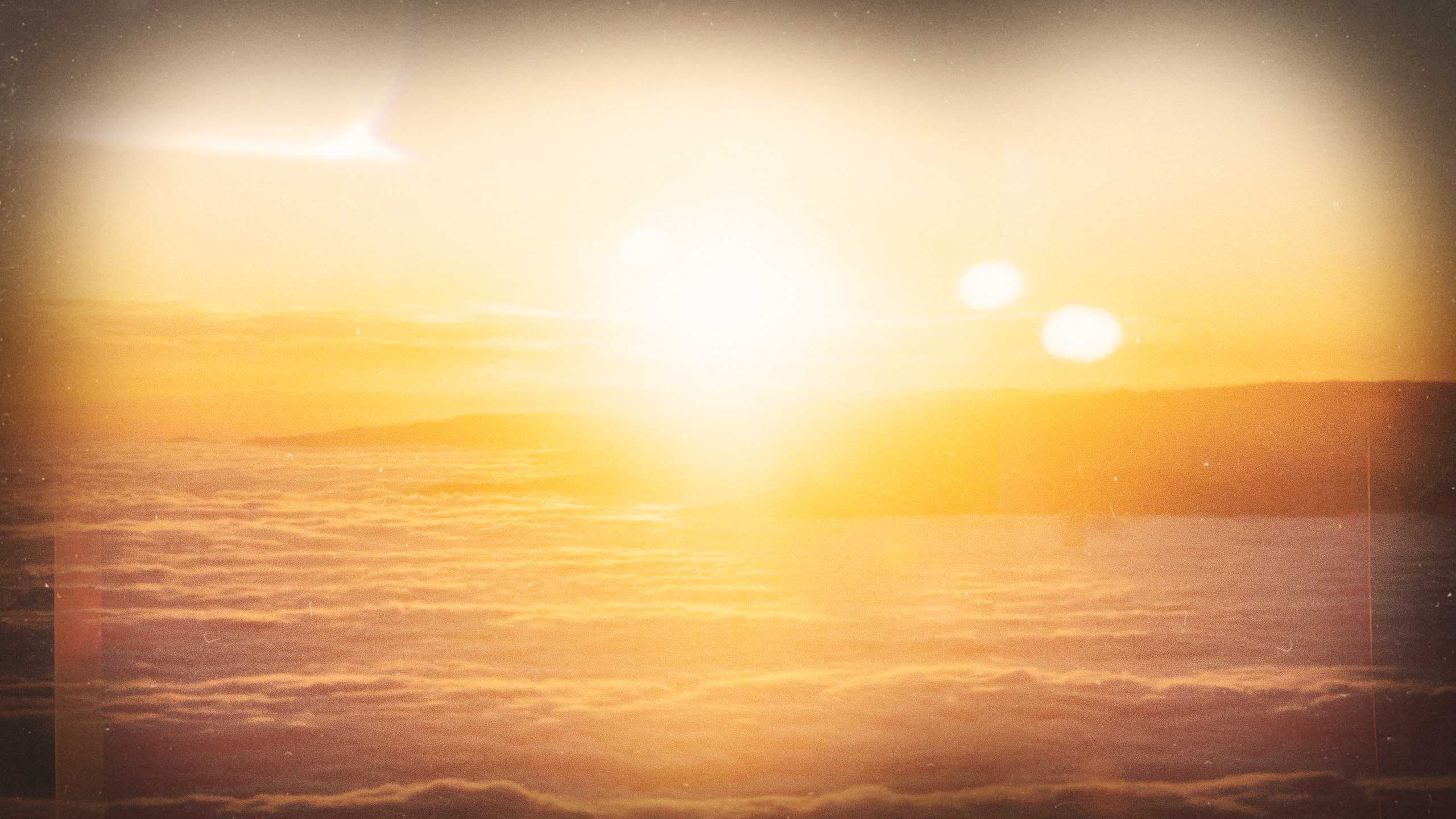 The sun burning through a layer of golden cloud, seen from above